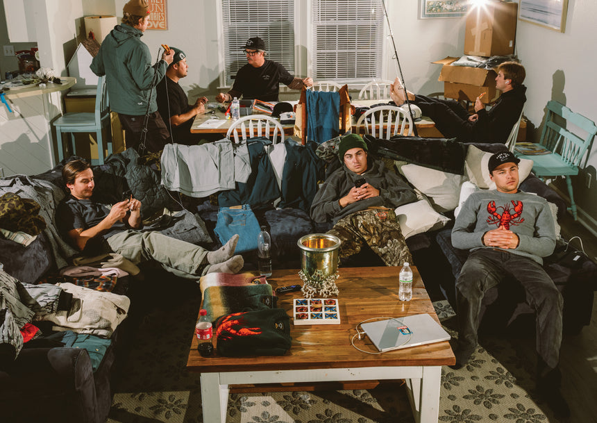Crew of seven people rigging tackle to go fishing and watching TV on a couch while eating.